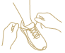 Outline of a person walking with a cane, accompanied by a small dog, on a paved pathway surrounded by trees and grass.